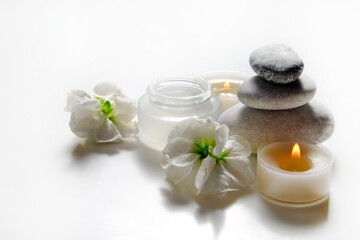 Fototapeta na wymiar Composition with symbolic objects for spa salon. Stone therapy attributes for cosmetic procedures. Conceptual image, rocks and flowers representing balance. Close up, copy space, top view, background.