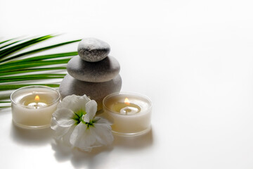 Fototapeta na wymiar Composition with symbolic objects for spa salon. Stone therapy attributes for cosmetic procedures. Conceptual image, rocks and flowers representing balance. Close up, copy space, top view, background.