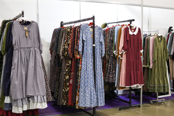 Hanging on a hanger are retro dresses, fabrics of different colors and textures.Mix of pastel...