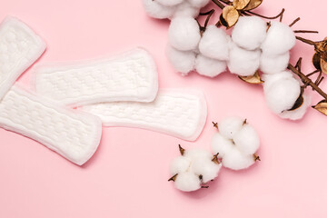 Women's hygiene daily pads on pink background and cotton sprigs, banner