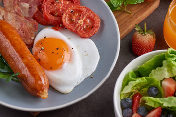 Delicious breakfast with fresh croissants, fried eggs with bacon and coffee served, orange juice. strawberry, butterhead, blackberry salad. full american breakfast top view.