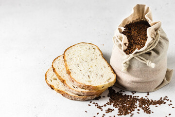 Flax seeds in a sack, slices of wholegrain bread. Space for text.
