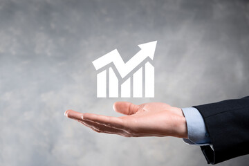 Fototapeta na wymiar Businessman man holding a graph with positive profits growth. plan graph growth and increase of chart positive indicators in his business.more profitable and growing.