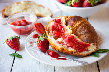 Croissants with strawberry jam and fresh fruit, delicious and healthy breakfast