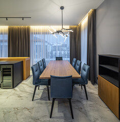 Huge wooden table and chairs. Interior of luxury kitchen in house.