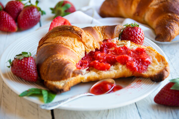 Croissants with strawberry jam and fresh fruit, delicious and healthy breakfast