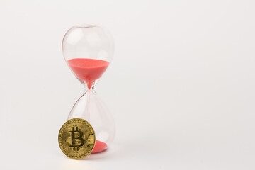 Hourglass and golden bitcoin. Currency time concept
