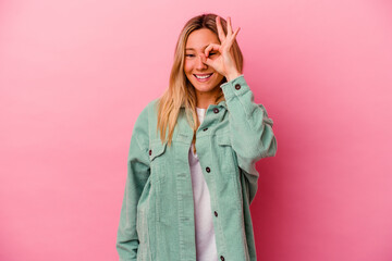 Young mixed race woman isolated on pink background excited keeping ok gesture on eye.