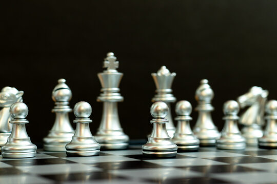 Silver pawn is on the first move in chess game on black background (Concept for business decision, start or beginning project)