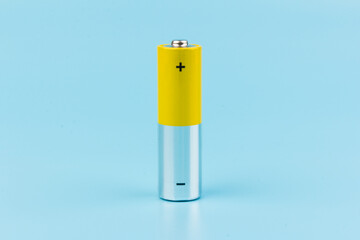 Photo of gray-yellow alkaline AA batteries on blue background. Recycling of rechargeable NiMH batteries. The most popular size of accumulators. Copy space.