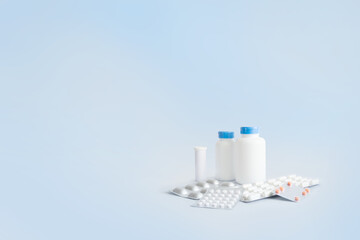 White jars for medicines and vitamins, tablets in packages.