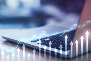 Investing concept with digital stock market chart and growing arrows at laptop background