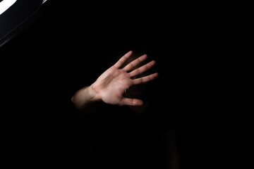 a man with a raised hand showing stop gesture on a black background