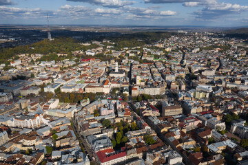 Aerial panoramic view on the beautiful town Ivano-Frankivsk in western Ukraine. Beautiful architecture, streets, autumn trees, blue sky with clouds. Urban photo, bird eye view.