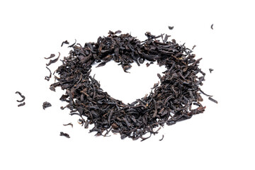 dry black tea heap isolated on white background. indian dried tea leaf cut out. heart shape