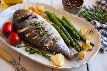 Roasted dorado fish with herbs and vegetables , healthy food