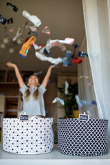 Household chores for children. Kids cleaning their room, sorting dry socks and arranging them into...