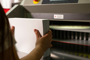 Woman prepare paper for cutting sheets close up view