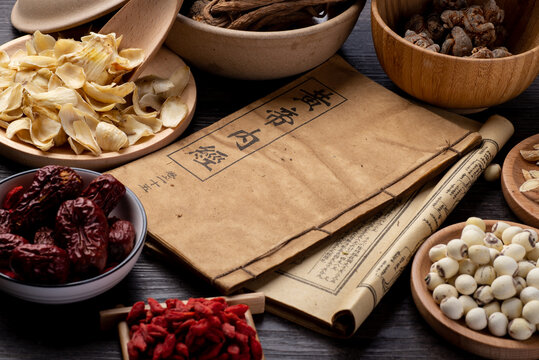 Ancient Chinese medicine books and herbs on the table