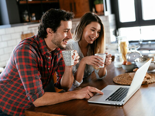  Loving couple drinking coffe in the kitchen. Happy smiling woman enjoy in the morning with her boyfriend.