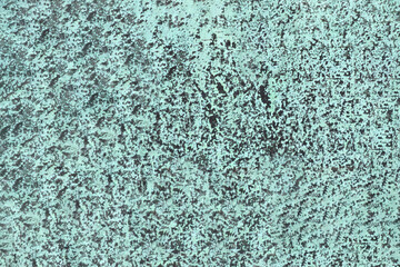 The surface of an old bronze plate, covered with a green patina.