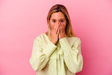 Young mixed race woman isolated on pink background shocked, covering mouth with hands, anxious to discover something new.