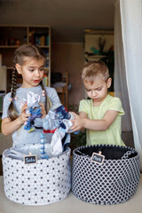 Household chores for children. Kids cleaning their room, sorting dry socks and arranging them into...