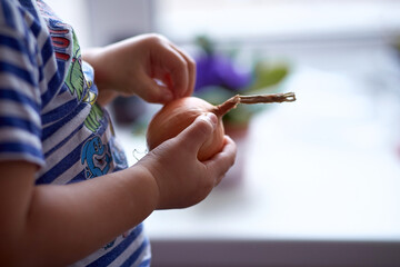 Child peels onions close up with copy space