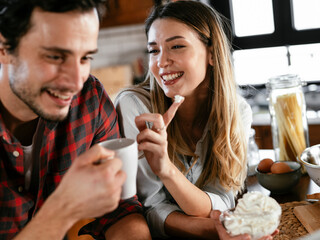  Loving couple drinking coffe in the kitchen. Happy smiling woman enjoy in the morning with her boyfriend.
