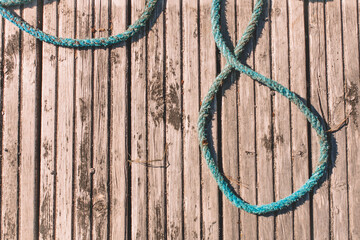 Obraz premium Old blue rope lies on a wooden deck