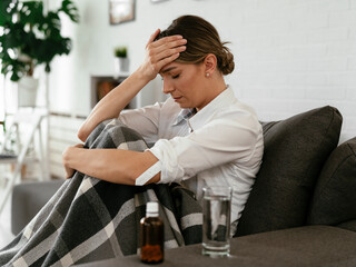 Obraz premium Young woman sick in bed. Woman drinking medicine, having stomach pain.