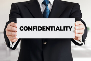 Businessman shows a banner with the word confidentiality. Business data or information secrecy protection