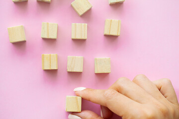 Woman hand putting and stacking blank wooden cubes on desk with copy space for input wording and infographic icon.