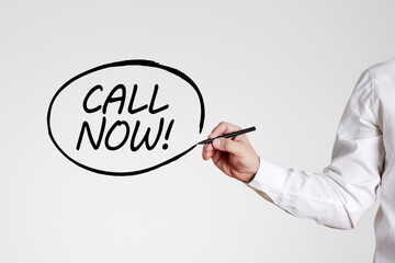 Businessman writes the word call now with an outline circle. Contact help desk support assistance