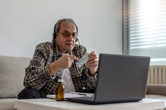 Photo of a senior male patient discuss about drug medicine with doctor in online using laptop computer. Elderly man having an online virtual consultation with his doctor while staying isolated at home