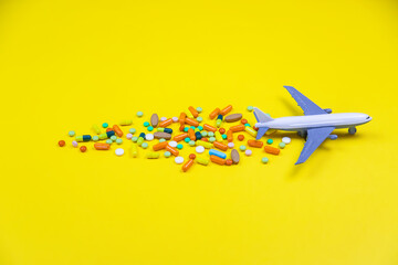 model airplane with multicolored pills from motion sickness close-up on a yellow background....