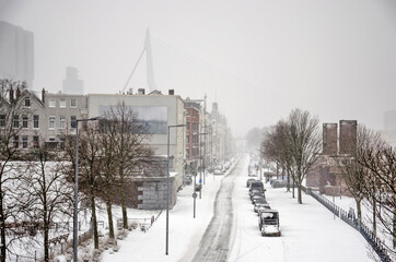 Rotterdam, The Netherlands, February 7, 2021: the snow-covered north quay of Noordereiland on a winter day, with Erasmus bridge in the background