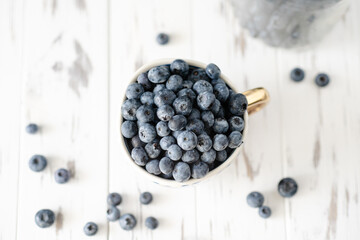 Fresh organic blueberry in cup on white background, top view