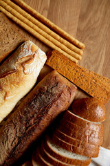 Top view of various kinds of bread on a wooden surface.
