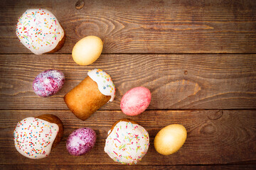 Easter cakes and Easter colored eggs on a wooden background.