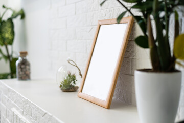 Mock up white frame on book shelf or desk. White colors.