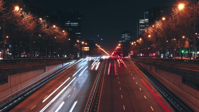 Time-lapse busy road of Paseo de la Castellana, illuminated Madrid city night scene street view. Europe, capital of Spain