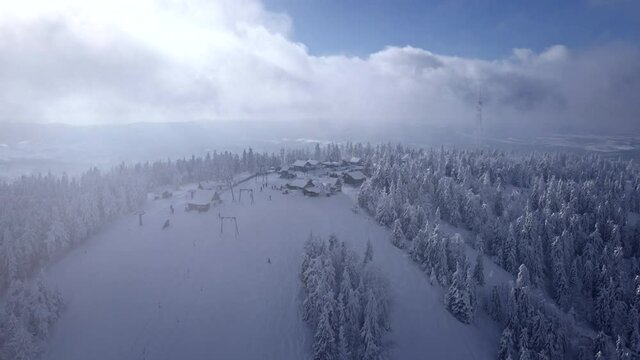 flight through clouds aerial view of mountains ski resort