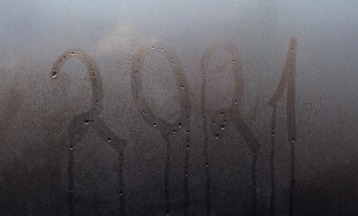 2021 on misted glass. The concept of the outgoing year.