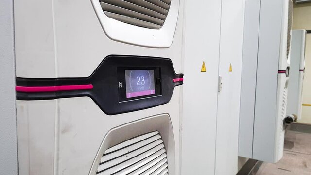 White big industrial conditioner on a door of electric equipment cabinet in automatic control room on a factory. Cooling of automation equipment.