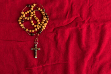 Rosary beads on red background.