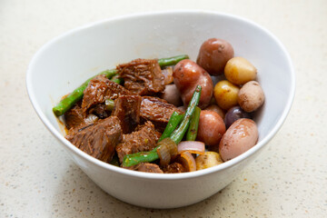 Tri-tip steak, green beans strings, onions in a cast iron cooking wok