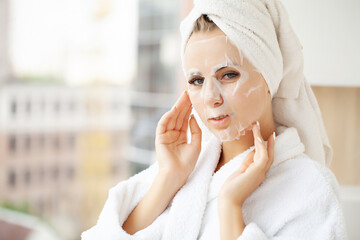 Pretty girl wearing face care mask at home