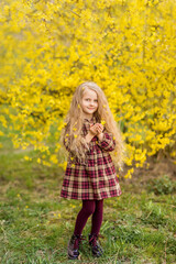 girl on a background of yellow flowers. A child in a blooming spring garden