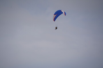 Almaty, Kazakhstan - 03.08.2021 : Tourists fly by parachute over a mountainous area near Almaty